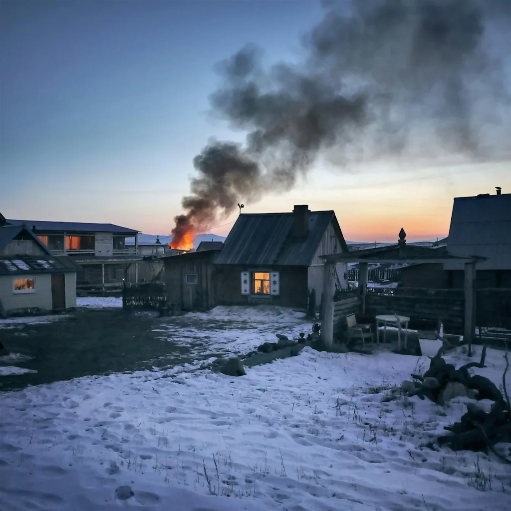 a group of houses with a fire in the chimney on one of the houses